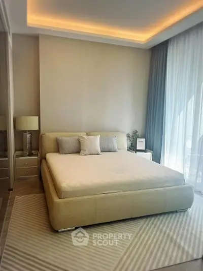 Luxurious bedroom with modern decor and large windows offering natural light.