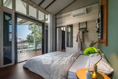 Charming bedroom with balcony access and modern decor in a cozy home.