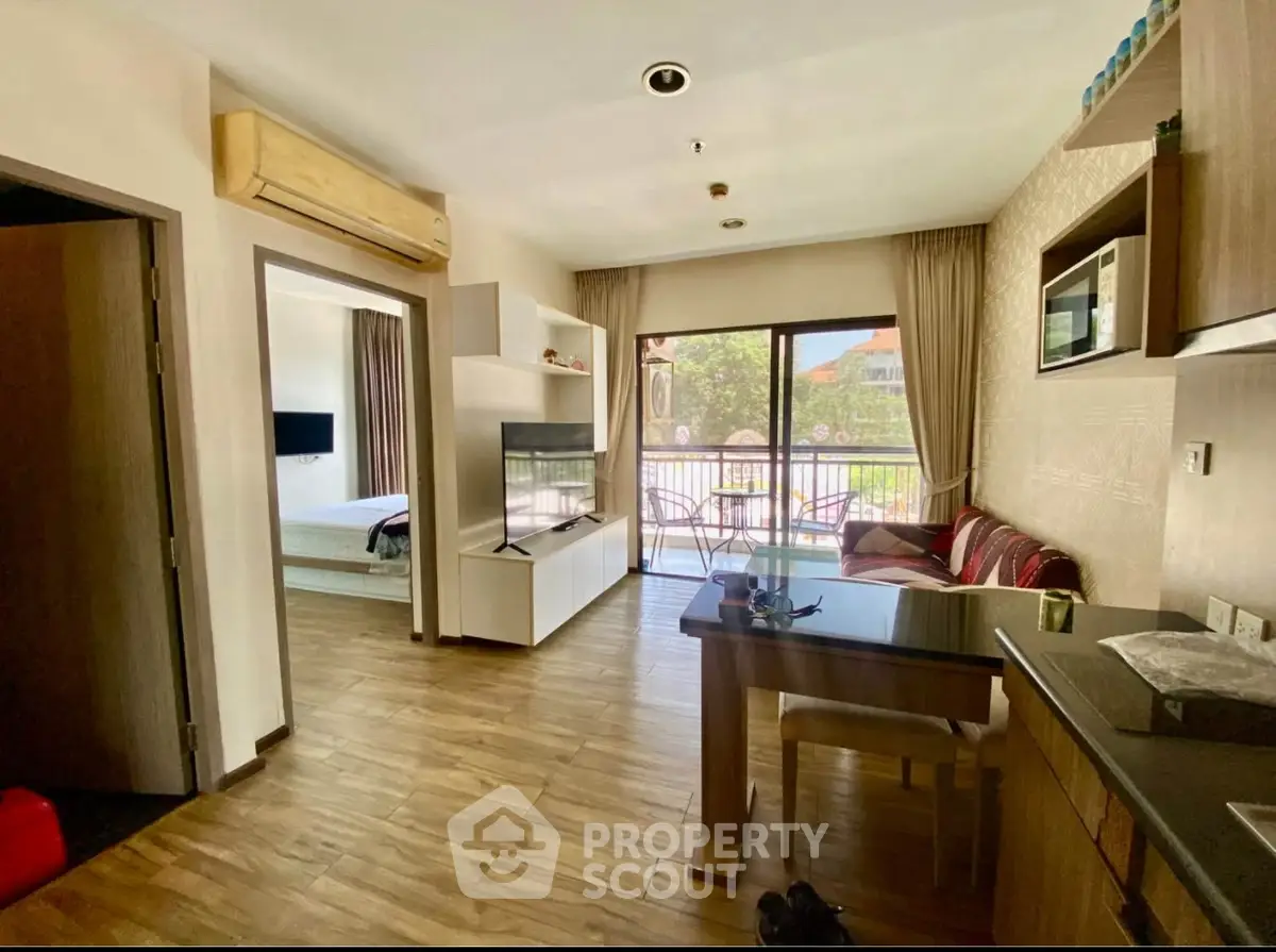 Modern open-plan living room with balcony view and stylish kitchen area.