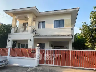 Charming two-story house with balcony and gated entrance, perfect for family living.