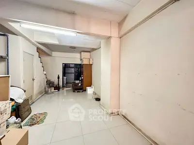 Spacious storage room with tiled flooring and ample shelving space.