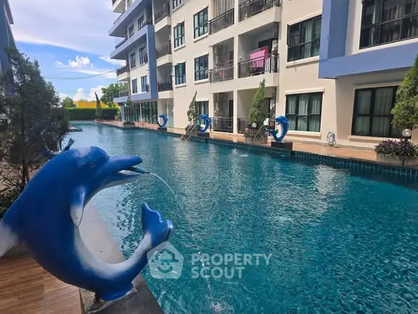 Luxurious apartment complex with stunning pool and dolphin fountain, perfect for relaxation and leisure.