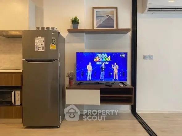 Modern living room with sleek kitchen appliances and mounted TV, perfect for urban living.