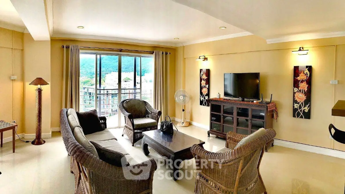 Spacious living room with wicker furniture and mountain view, ideal for relaxation.