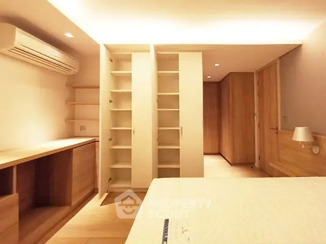 Spacious bedroom with built-in storage and modern lighting