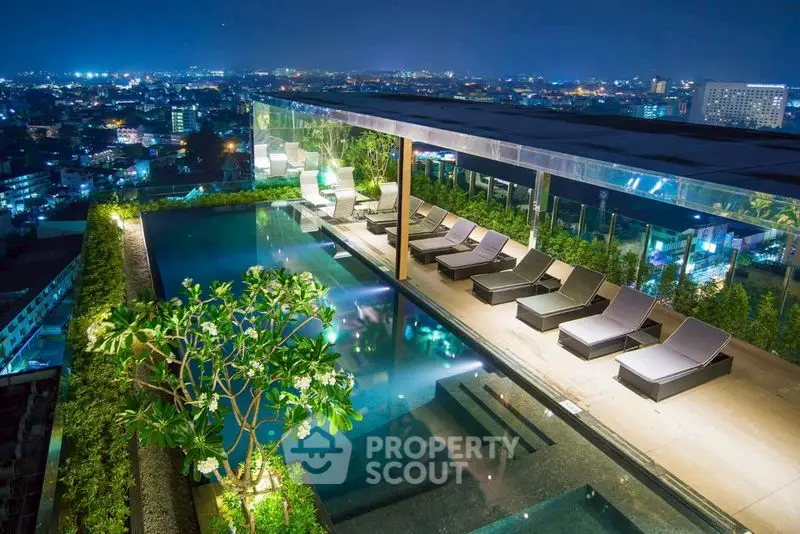 Luxurious rooftop pool with stunning city views at night, perfect for relaxation and entertainment.