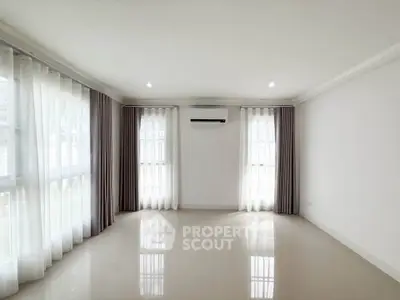 Spacious and bright living room with large windows and modern air conditioning unit.