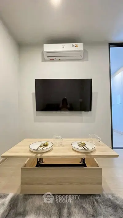 Modern living room with wall-mounted TV and stylish dining setup