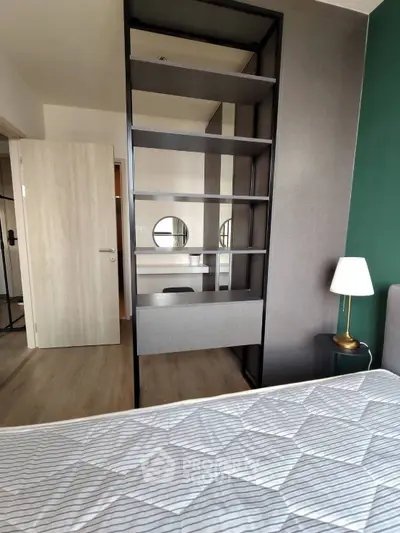 Modern bedroom with stylish shelving and cozy decor in a contemporary apartment.