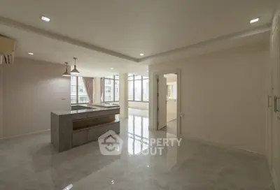 Spacious open-plan living area with modern kitchen and large windows for natural light.
