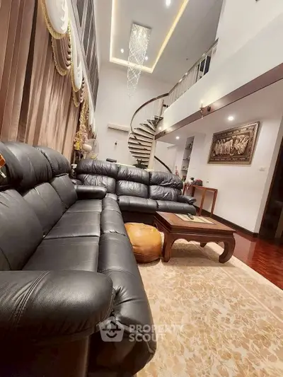Luxurious living room with elegant spiral staircase and plush leather sofas.