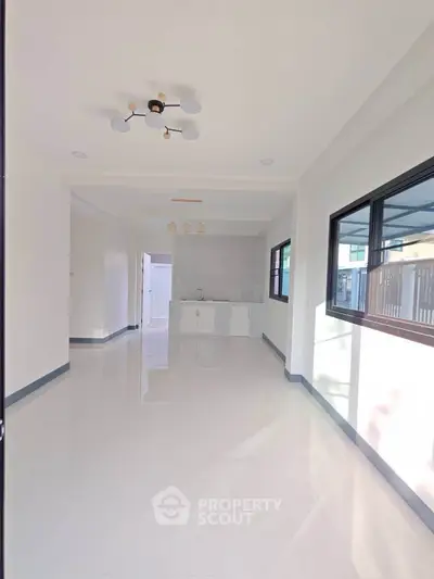 Spacious modern interior with sleek white flooring and ample natural light.