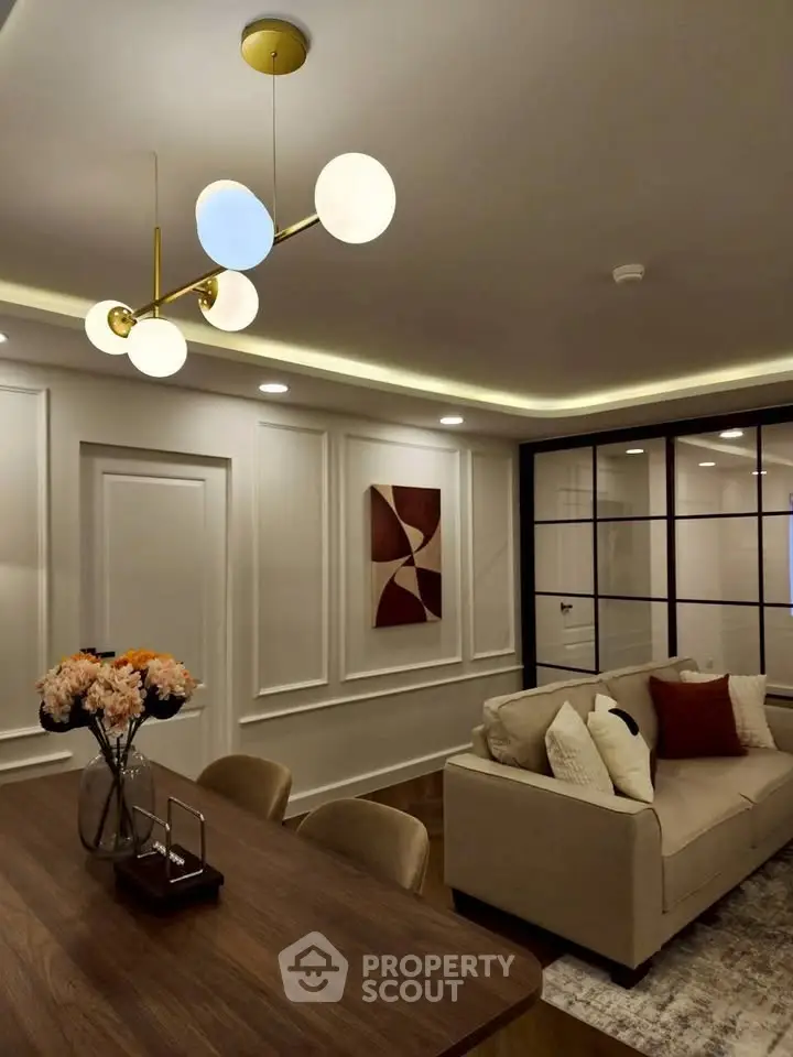 Elegant living room with modern lighting and stylish decor, featuring a cozy sofa and chic wall art.