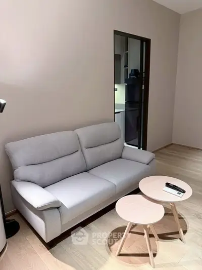 Modern living room with cozy gray sofa and stylish nested tables, perfect for relaxation and entertainment.