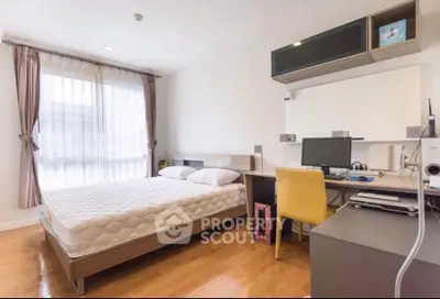 Modern bedroom with study area, featuring a large window and sleek furniture.