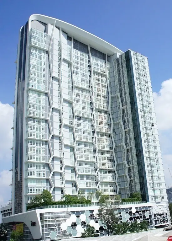 Modern high-rise building with unique geometric facade and lush greenery