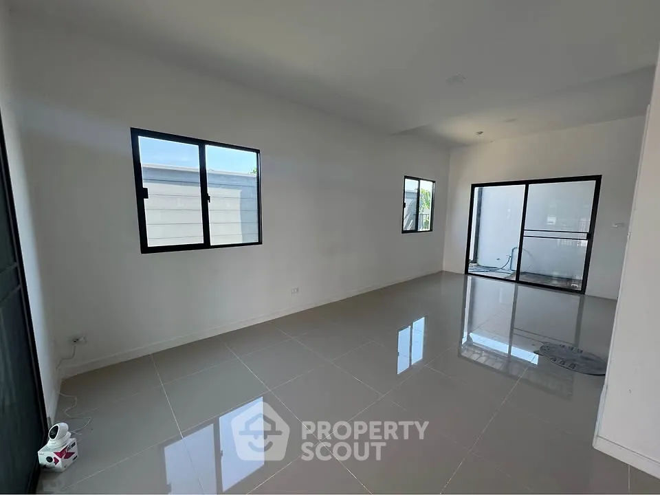 Spacious modern living room with large windows and glossy tiled floors