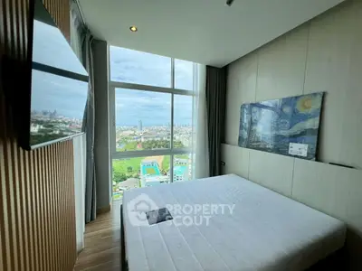 Modern bedroom with large window offering stunning city view and stylish decor.