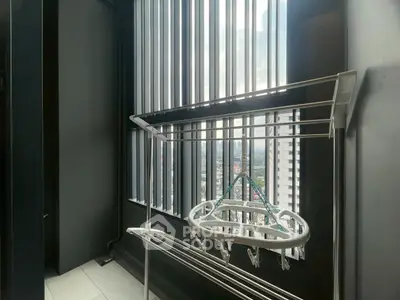 Modern balcony with city view and drying rack in high-rise apartment