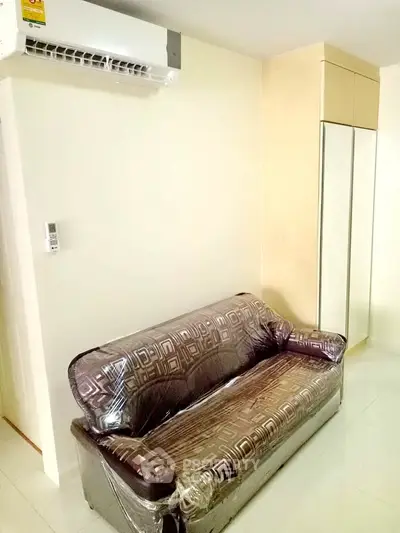 Cozy living room with modern sofa and air conditioning in a stylish apartment.