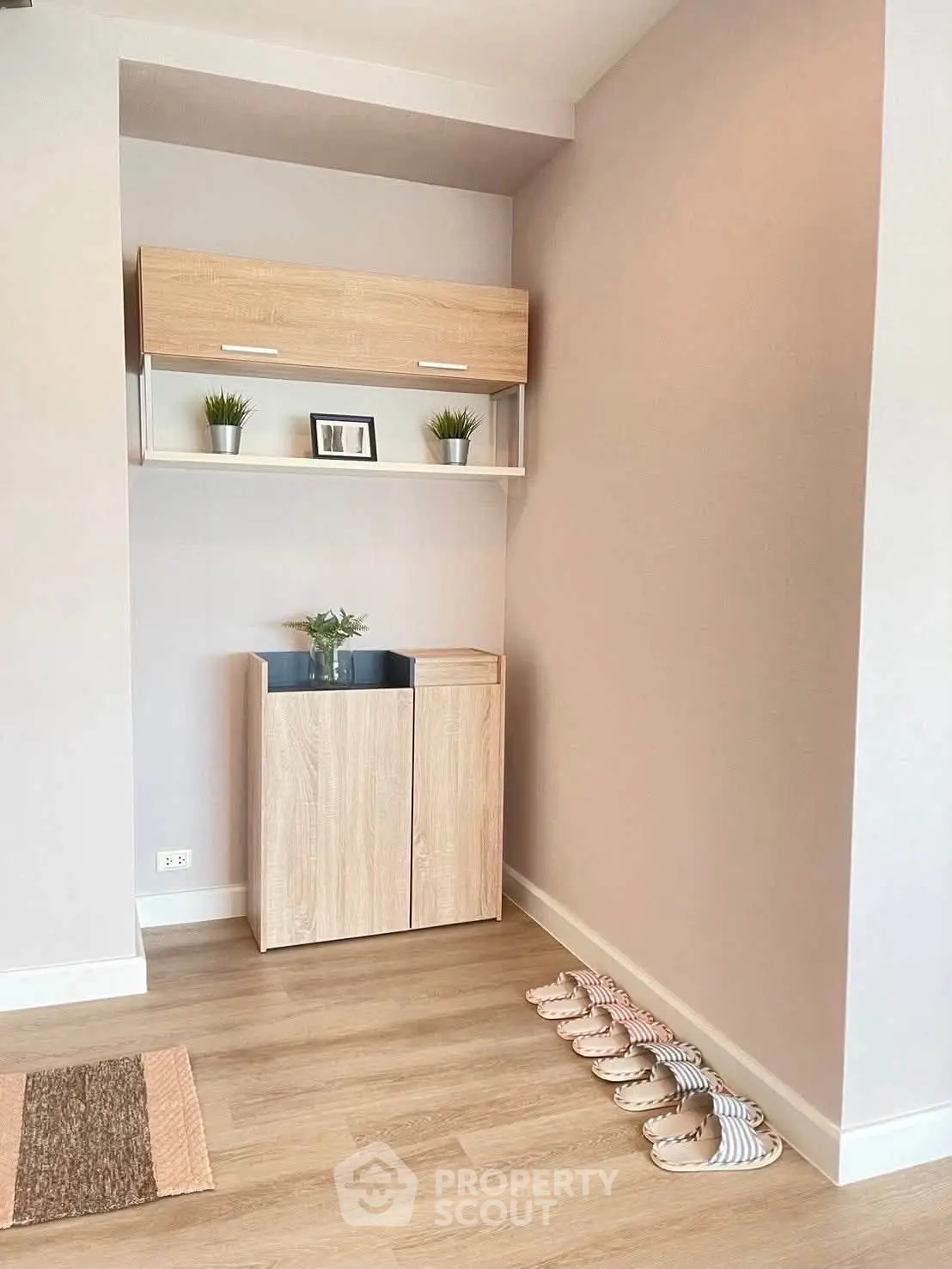 Modern entryway with stylish wooden cabinet and decorative plants, perfect for welcoming guests.