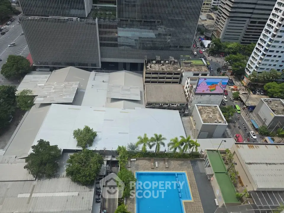 Aerial view of urban landscape with pool and high-rise buildings, showcasing city living amenities.