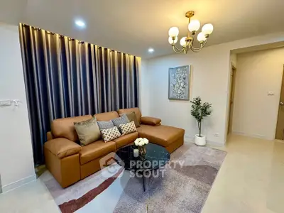 Elegant living room with modern decor, featuring a stylish brown sofa, chic chandelier, and artistic wall accents.