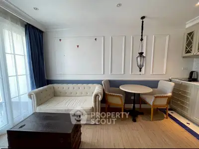 Charming living room with elegant decor, featuring a cozy sofa, stylish pendant light, and a quaint dining area.