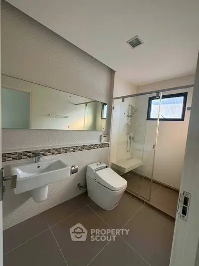 Modern bathroom with sleek fixtures and glass shower enclosure