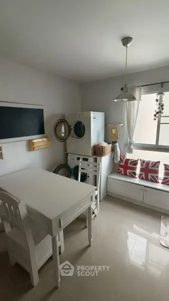 Charming kitchen with washing machine and cozy seating area, perfect for modern living.