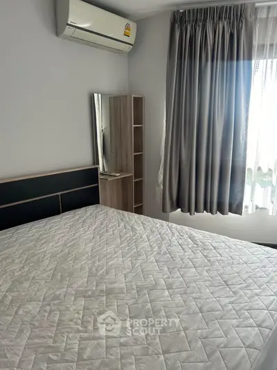 Cozy bedroom with air conditioning and natural light, perfect for relaxation.