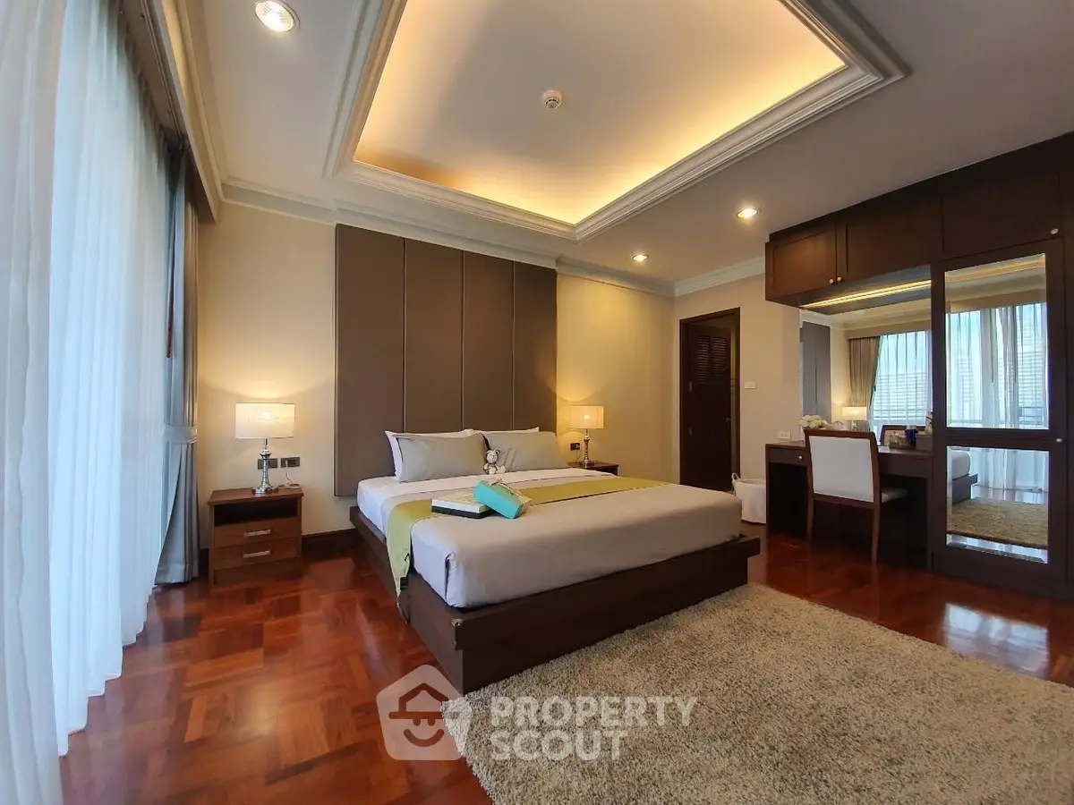 Luxurious bedroom with elegant decor and plush carpeting in a modern home.