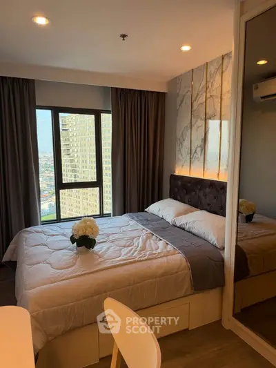Luxurious bedroom with city view, elegant decor, and natural light in modern apartment.