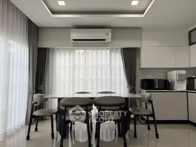 Modern kitchen with sleek dining area and large windows for natural light