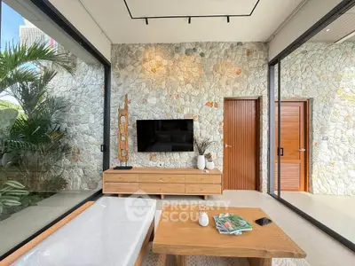Modern living room with stone wall, large windows, and wooden furniture
