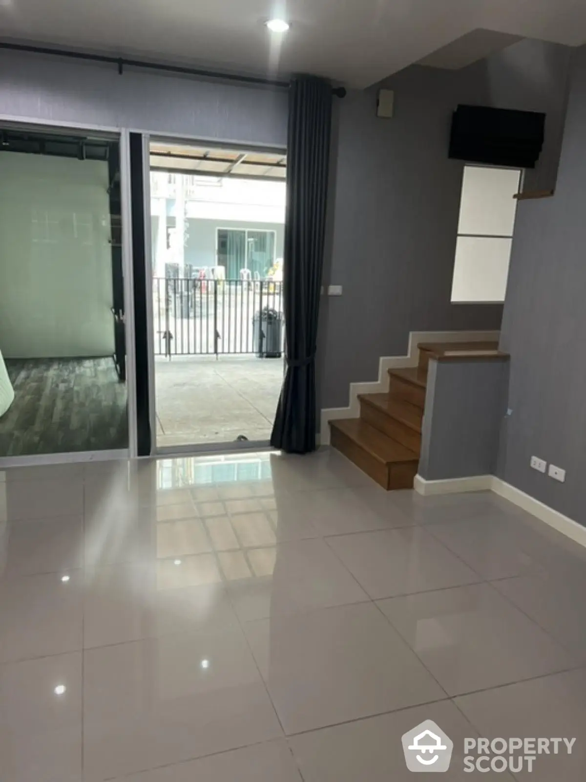 Modern interior with sleek tiled flooring and staircase, ideal for contemporary living.