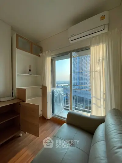 Cozy living room with balcony view in modern apartment, featuring sleek furniture and natural light.