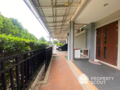 Charming residential entrance with covered walkway and lush greenery