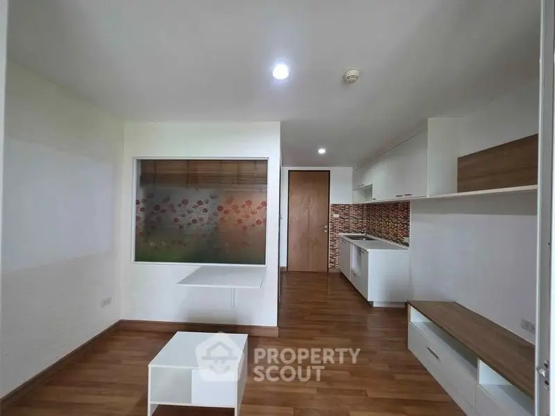 Modern living room with wooden flooring and stylish kitchen area