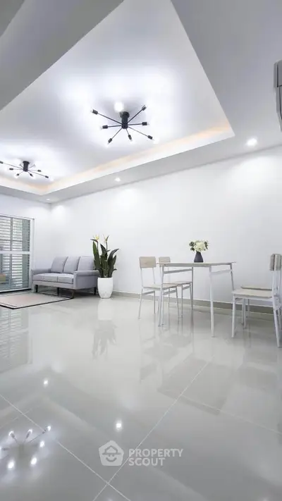 Modern living room with sleek design, featuring elegant lighting and minimalist furniture.