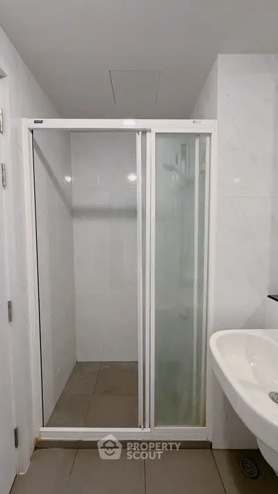 Modern bathroom with glass shower enclosure and sleek white sink