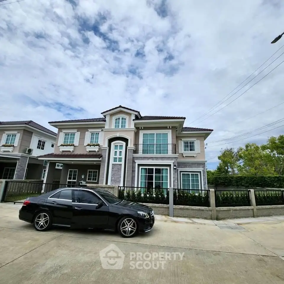 Elegant two-story house with modern architecture and luxury car parked in front.