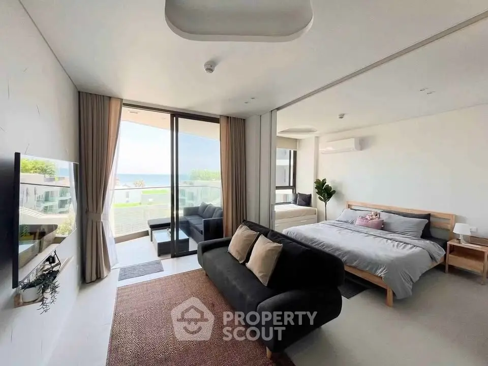Modern studio apartment with ocean view, featuring cozy living area and stylish bedroom.