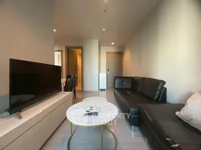 Modern living room with sleek black sofa and large flat-screen TV