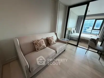 Modern living room with elegant sofa and view into stylish bedroom
