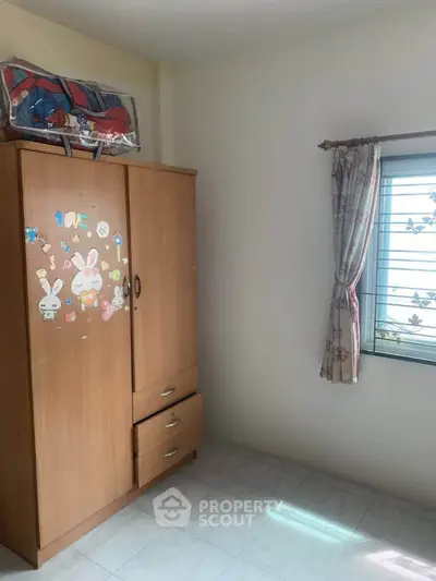Cozy bedroom with wardrobe and window, perfect for personalizing your space.