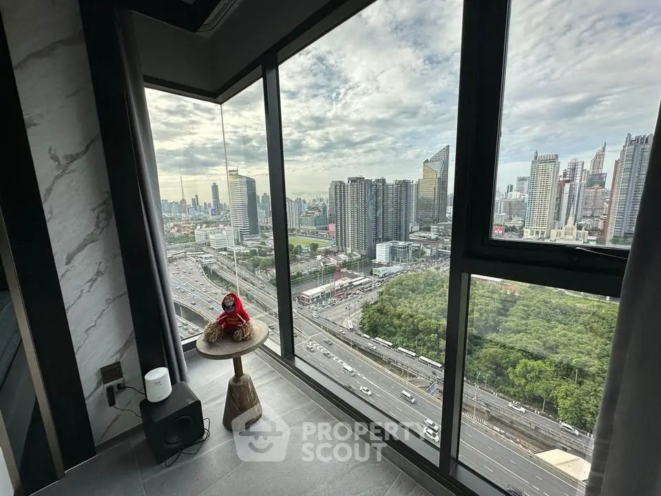 Stunning cityscape view from modern high-rise apartment corner unit with floor-to-ceiling windows.