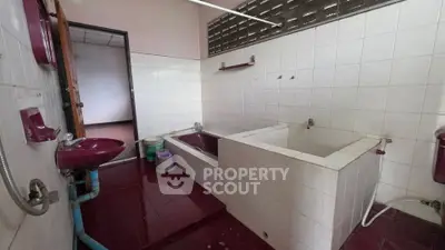 Spacious bathroom with dual bathtubs and tiled walls, offering a unique layout for relaxation.