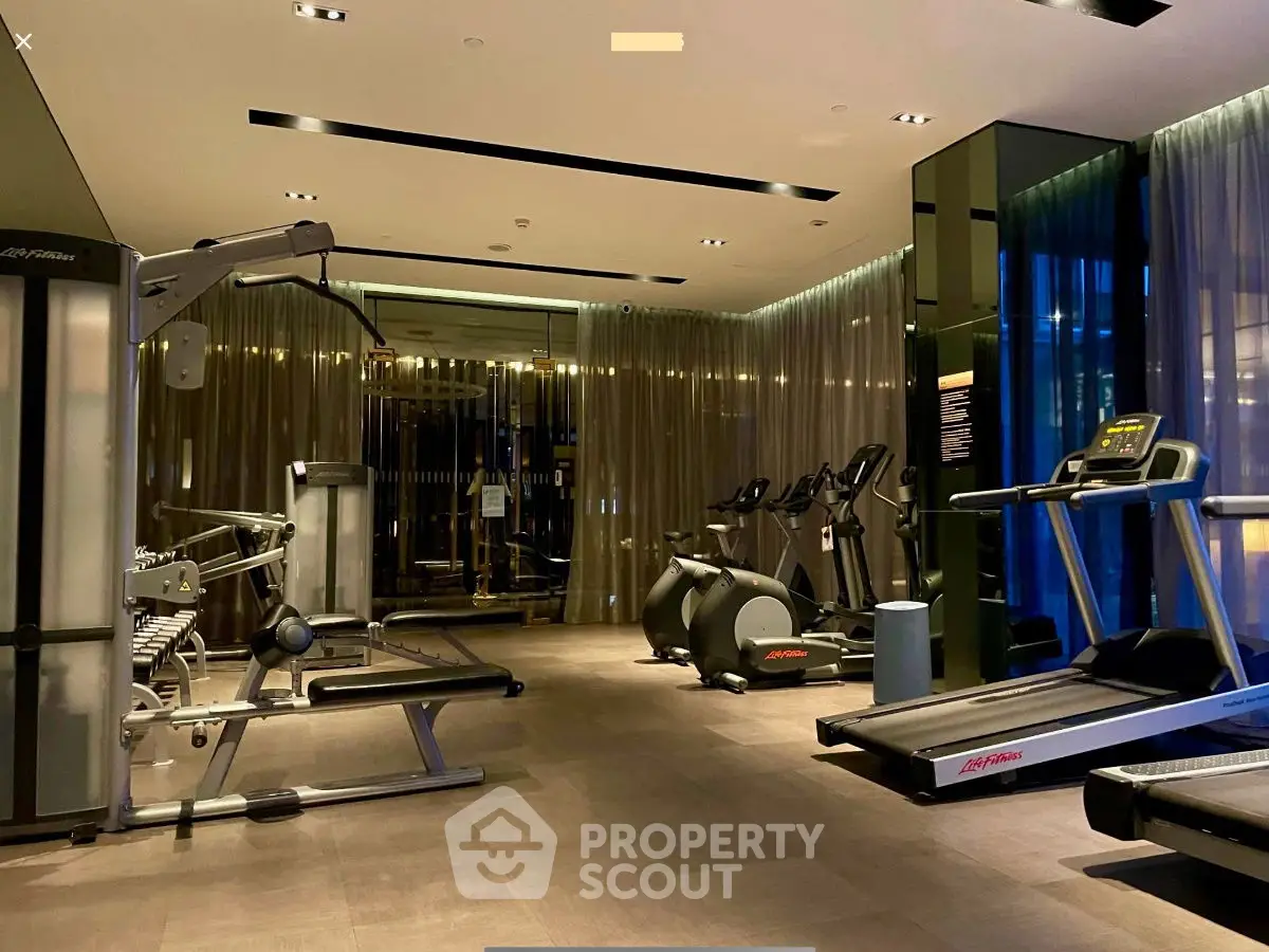 Luxurious modern gym with state-of-the-art equipment and ambient lighting in a high-end residential building.