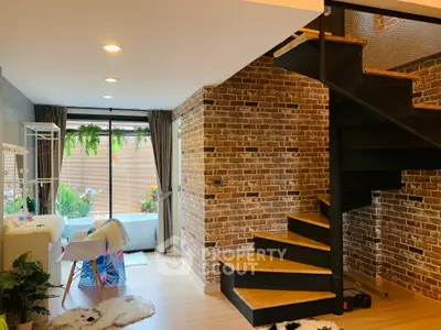 Charming duplex living room with exposed brick walls and modern staircase